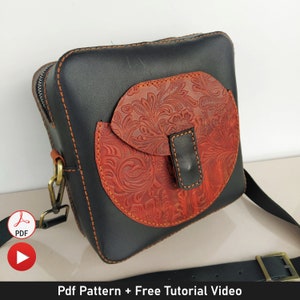 May include: A black leather crossbody bag with a brown floral embossed flap pocket. The bag has a strap and a buckle closure.  Pdf Pattern + Free Tutorial Video