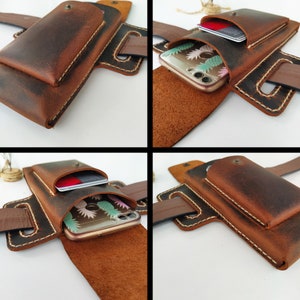 May include: A brown leather phone and card holder with a belt loop. The holder has two pockets, one for a phone and one for cards. The phone pocket is open and a phone with a pineapple design case is visible.