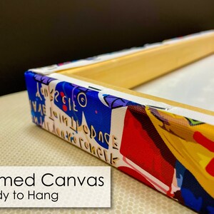 May include: A framed canvas print with a colorful abstract design. The canvas is stretched over a wooden frame and is ready to hang.