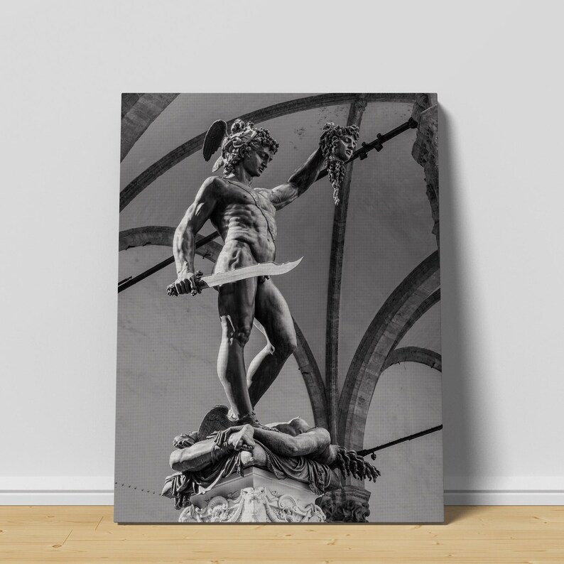 May include: Black and white photograph of a statue of a man holding a sword and the severed head of a woman. The statue is in a public square with arches in the background.