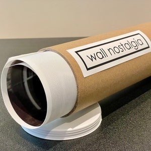 May include: A brown cardboard tube with a white label that says "wall nostalgia" on it. The tube is wrapped in white paper and has a black and white image inside.