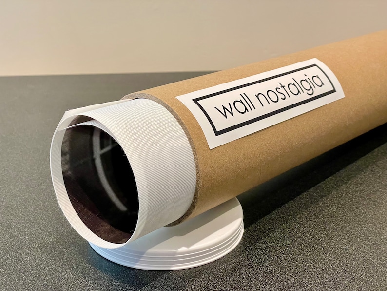 May include: A brown cardboard tube with a white label that says "wall nostalgia" on it. The tube is wrapped in white paper and has a black and white image inside.