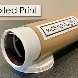 May include: A rolled print of a photograph or artwork is packaged in a brown cardboard tube with a white label that says "wall nostalgia".