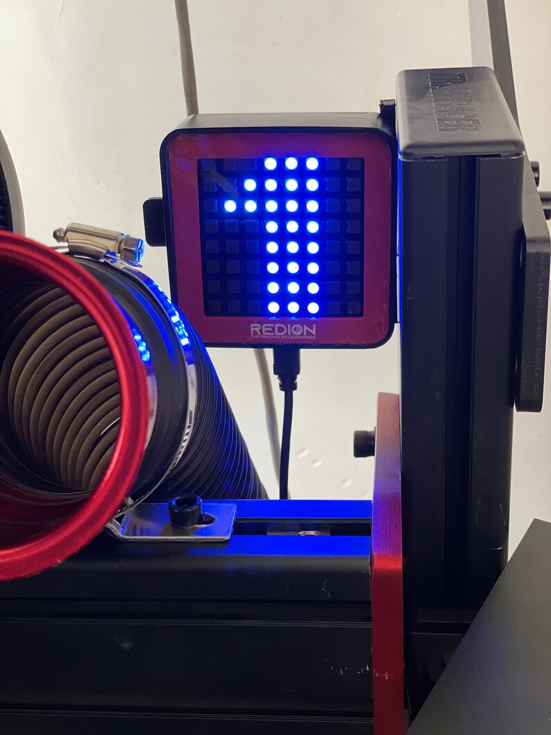 May include: A black and red digital display with the number 1 illuminated in blue. The display is mounted on a black frame with a red accent. The word "REDION" is printed on the display.