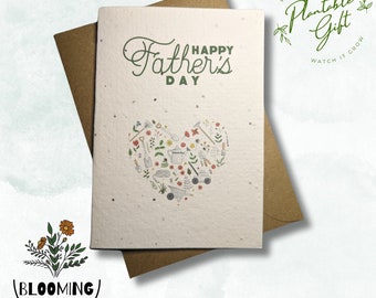 May include: A white card with the text "Happy Father's Day" and a heart-shaped design made of gardening tools and flowers. The card is made of plantable paper and has the text "Plantable Gift" on the back.