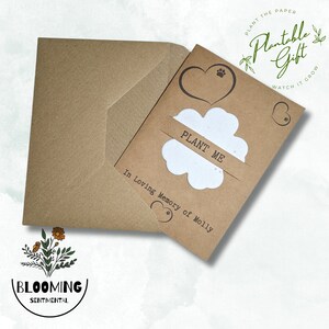 May include: A brown card with a white paper flower that says "PLANT ME" inside. The card has a brown envelope and says "Plantable Gift" in a circle with green leaves. The card also says "In Loving Memory of Molly".
