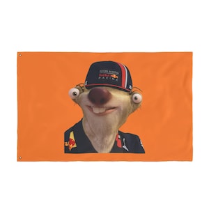 May include: Orange flag featuring a cartoon sloth wearing an Aston Martin Red Bull Racing cap. The sloth has a large nose, buck teeth, and is wearing a dark blue racing shirt. The flag is rectangular with grommets in the corners.