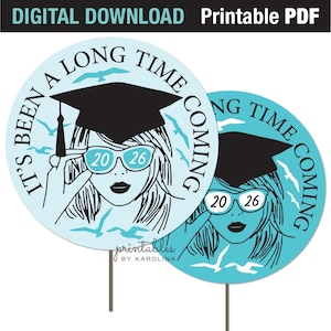 May include: Two light blue graduation yard signs with a graphic of a woman wearing glasses with the numbers "2026". The signs have the text "It's been a long time coming". The top of the signs read "Digital Download Printable PDF".