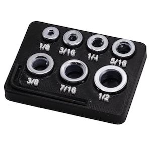 May include: A black plastic tool holder with eight silver metal drill bits. The drill bits are labeled with their sizes: 1/8, 3/16, 1/4, 5/16, 3/8, 7/16, and 1/2.