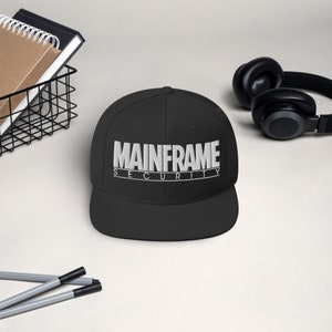 Puede incluir: Una gorra de béisbol negra con un logotipo bordado en blanco que dice "MAINFRAME SECURITY".