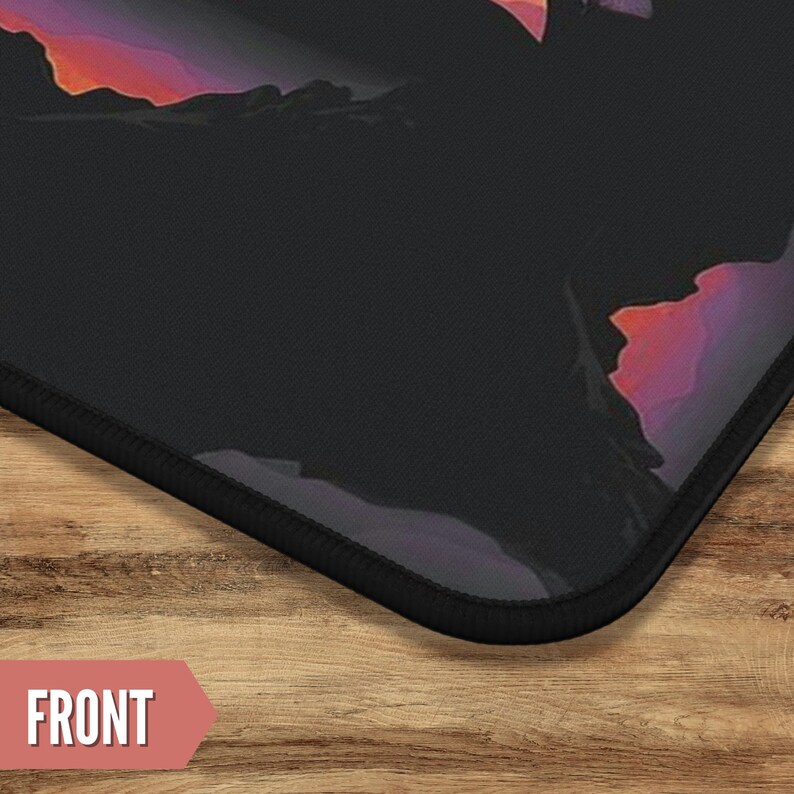 May include: A black mousepad with a colorful sunset design. The mousepad has a black stitched edge.