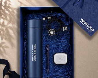 May include: A navy blue gift box containing a matching navy blue vacuum insulated water bottle, a black multi-charging cable with a circular logo tag, a navy blue ballpoint pen, and a white wireless earbud charging case, all with YOUR LOGO HERE.