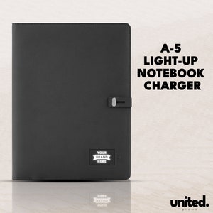 May include: A black A-5 notebook charger with a white light-up area that says "YOUR BRAND HERE". The charger is on a white surface with the text "united. promo" in the bottom right corner.