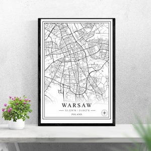 May include: Black and white map print of Warsaw, Poland with the city's coordinates and name. The map is framed in a black frame and is displayed on a white surface.