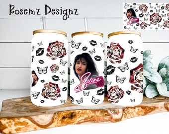 Könnte beinhalten: Drei weiße Edelstahlbecher mit Deckel und Strohhalmen. Jeder Becher hat ein anderes Design mit einem schwarz-weißen Schmetterling, einer roten Rose und einem schwarz-weißen Bild von Selena. Der mittlere Becher hat den Text "Selena" in pinken Neonbuchstaben.