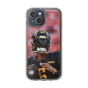 Pode incluir: Capa de telefone transparente com um jogador de futebol americano com capacete e camisa pretos. O jogador está segurando uma bola de futebol. O fundo é uma imagem desfocada de um estádio. A camisa tem a palavra "Commanders".