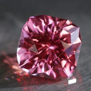 Peut inclure: Une pierre pr&eacute;cieuse rose &agrave; facettes, refl&eacute;tant la lumi&egrave;re en forme d'&eacute;toile.