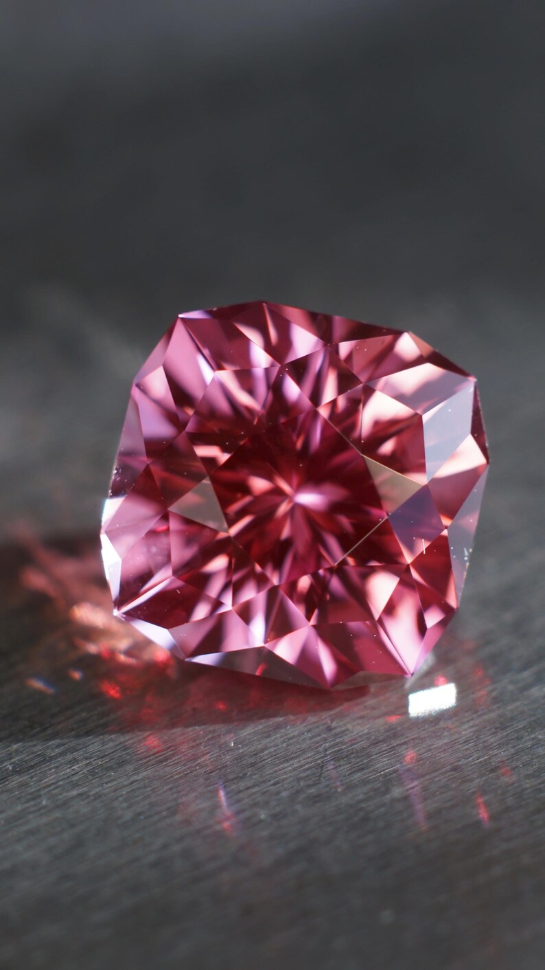 Peut inclure: Une pierre pr&eacute;cieuse rose &agrave; facettes, refl&eacute;tant la lumi&egrave;re en forme d'&eacute;toile.