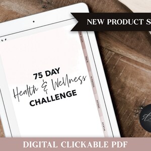May include: A digital tablet shows the words "75 DAY Health & Wellness CHALLENGE" in black text on a white background. A banner at the top reads "NEW PRODUCT SALE!" and the words "DIGITAL CLICKABLE PDF" are at the bottom. The tablet is on a wooden surface.