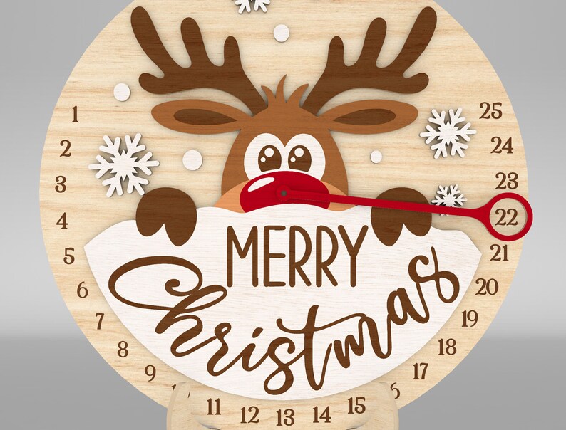K&ouml;nnte beinhalten: Ein h&ouml;lzerner Weihnachts-Countdown-Timer mit einem Rentier, das &uuml;ber den Rand schaut. Die Uhr hat einen roten Zeiger und die Aufschrift "Merry Christmas" auf der Vorderseite. Die Zahlen von 1 bis 25 sind um die Uhr herum angeordnet.