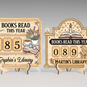 Peut inclure: Deux panneaux en bois pour compter les livres lus. L'un affiche "Books Read This Year" avec le nombre "085" et "Sophia's Library" en dessous. L'autre affiche "Books Read This Year" avec le nombre "089" et "Martin's Library" en dessous.