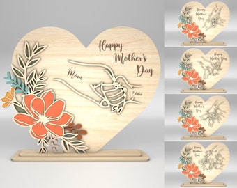 May include: A wooden heart-shaped sign with a floral design and the text "Happy Mother's Day". The sign also includes the words "Mom" and "Eddie".