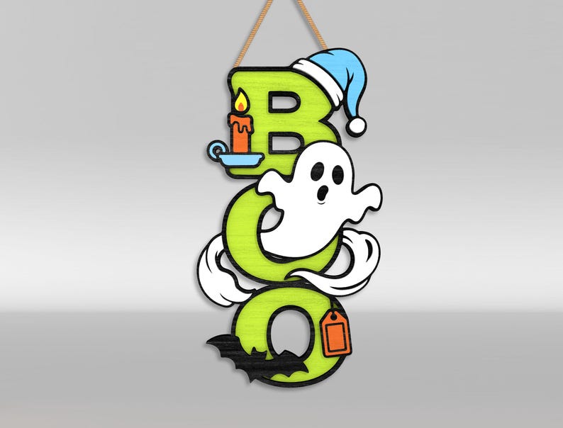 Op de afbeelding: Een verticaal hangbord met de tekst BOO in limoengroene letters. De B heeft een blauwe slaapmuts en een brandende oranje kaars. Een wit spook zweeft door de O en een zwarte vleermuis is aan de onderkant van de laatste O bevestigd met een oranje label.