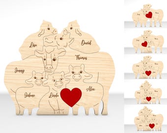 Peut inclure: Une découpe en bois d'une famille de vaches avec un cœur rouge au centre. Les vaches sont disposées en cercle avec les noms Jenny, Sidane, Linda, Alex, Thomas, David, Lisa et le mot "Famille" au centre.