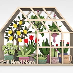 May include: Wooden greenhouse-shaped decorative piece with a variety of colorful plants and a lemon tree. The text "Still Need More!" is at the base. The plants are in various pots, and the greenhouse has a light wood frame.
