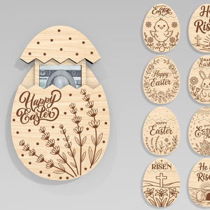 May include: Wooden Easter egg-shaped money holder with "Happy Easter" script and floral design. Additional wooden Easter egg ornaments with various designs, including a chick, bunny, and the phrase "He is Risen."