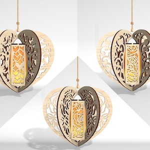 Op de afbeelding: Drie houten, hartvormige hangende lantaarns met ingewikkelde uitgesneden ontwerpen en warmwitte LED-verlichting. De lantaarns hangen aan een witte achtergrond.