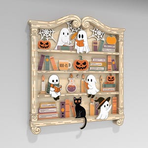 May include: Wooden Halloween-themed bookshelf with cartoon ghosts, pumpkins, books, and a black cat. The bookshelf has multiple shelves with various Halloween decorations. The text "BOO-KS" is visible on a mug. The overall design is whimsical and festive.