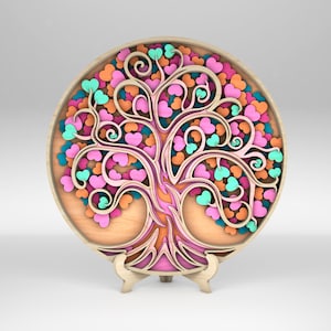 May include: A wooden wall art piece shaped like a tree with a circular base. The tree is decorated with pink, orange, and teal hearts.