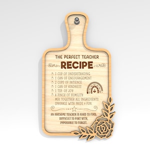 Puede incluir: Un letrero de madera con forma de tabla de cortar con el texto "The Perfect Teacher Recipe" y una lista de ingredientes para un maestro, que incluyen comprensión, aliento, paciencia, amabilidad, alegría y humildad. El letrero está decorado con un diseño floral y un arcoíris.