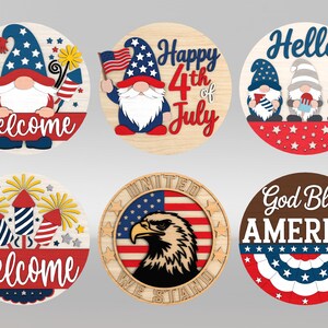 Op de afbeelding: Zes ronde houten borden met patriottische ontwerpen. De borden tonen kabouters, vuurwerk, een adelaar en de zinnen "Welcome", "Happy 4th of July", "Hello", "God Bless America" en "United We Stand". De borden zijn in rood, wit, blauw en geel.