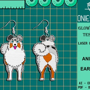 May include: A pair of laser cut earrings featuring a blue merle Australian Shepherd dog. The dog is shown in two poses, one facing forward and the other facing backward. The earrings are made of wood and have a silver hook.