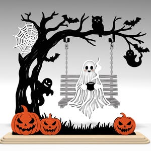 Puede incluir: Decoración de madera con temática de Halloween. Un árbol negro con murciélagos, un búho y una telaraña. Un fantasma está sentado en un columpio, sosteniendo un caldero. Calabazas naranjas en la base del árbol.