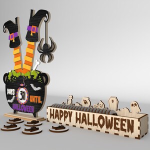 May include: A wooden Halloween countdown calendar with a witch's legs sticking out of a cauldron. The cauldron has a chalkboard with the text "Days Until Halloween" and a number 31. The calendar also includes a wooden box with the text "Happy Halloween" and various Halloween-themed decorations.
