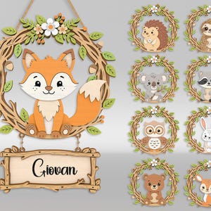 May include: Wooden wall decor featuring a fox, a wreath, and a sign that reads "Giovan". Additional wooden wreaths with various woodland animals are also shown, including a hedgehog, sloth, koala, raccoon, owl, rabbit, bear, and deer.