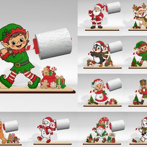 May include: A collection of ten decorative wooden toilet paper holders featuring various Christmas characters including an elf, Santa, a reindeer, a penguin, a nutcracker, a gingerbread person, a snowman, a gnome, and a polar bear on a base.