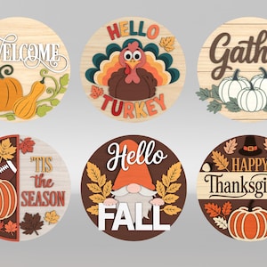 May include: A collection of six round wooden signs with fall and Thanksgiving themes. Designs include pumpkins, turkeys, gnomes, and the phrases "Welcome," "Gather," "'Tis the Season," "Hello Fall," and "Happy Thanksgiving."