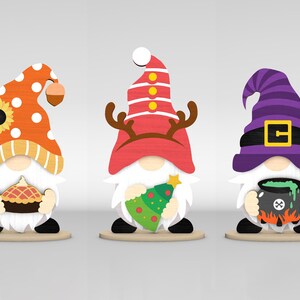 May include: Three wooden gnome figurines. The first gnome wears an orange hat with white polka dots and holds a pie. The second gnome has a red hat with antlers and holds a Christmas tree. The third gnome wears a purple witch hat and holds a cauldron.