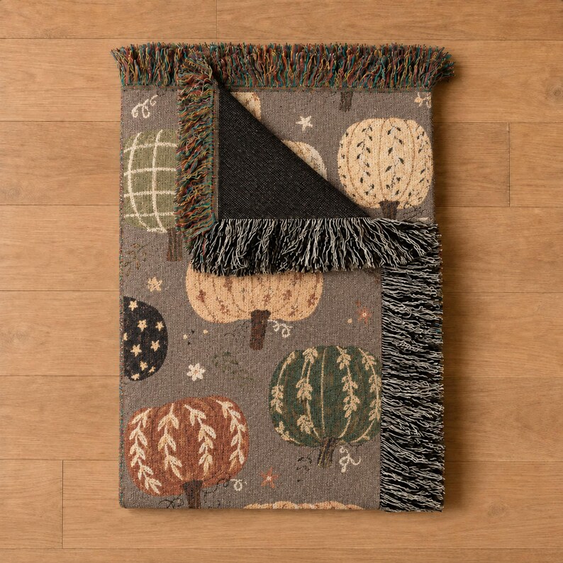 Rustic pumpkin blanket featuring charming patchwork designs, vibrant autumn florals, leafy stems, and earthy seasonal tones. A cozy woven throw with fringe for adding warmth and texture to Halloween decor, fall bedrooms, living rooms, and seasonal displays.