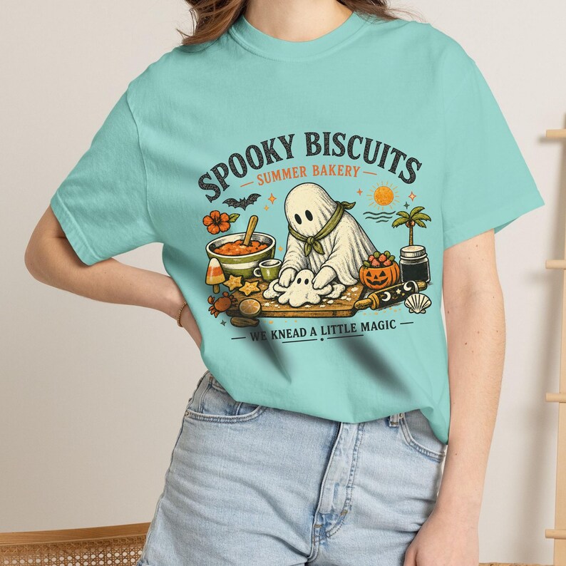 Cute spooky bakery tee featuring an adorable ghost making biscuits and the playful wording “Spooky Biscuits.” This Comfort Colors Summerween shirt combines Halloween magic with warm summer vibes, perfect for bakers, ghost fans, beach trips, pool parties, vacations, and spooky season outfits.