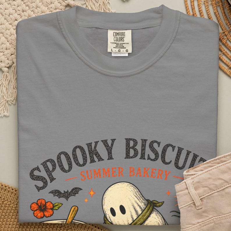 Funny Halloween baking shirt featuring a sweet ghost kneading dough in a whimsical summer bakery design. The “Spooky Biscuits” artwork makes this Comfort Colors Summerween tee a playful gift for bakers, Halloween lovers, ghost fans, beach vacations, pool parties, and seasonal events.