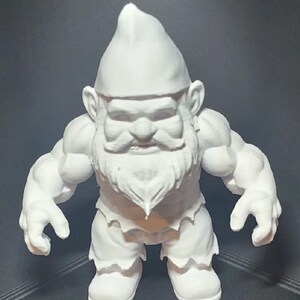 May include: A white, 3D printed figurine of a muscular gnome with a beard and a pointed hat.
