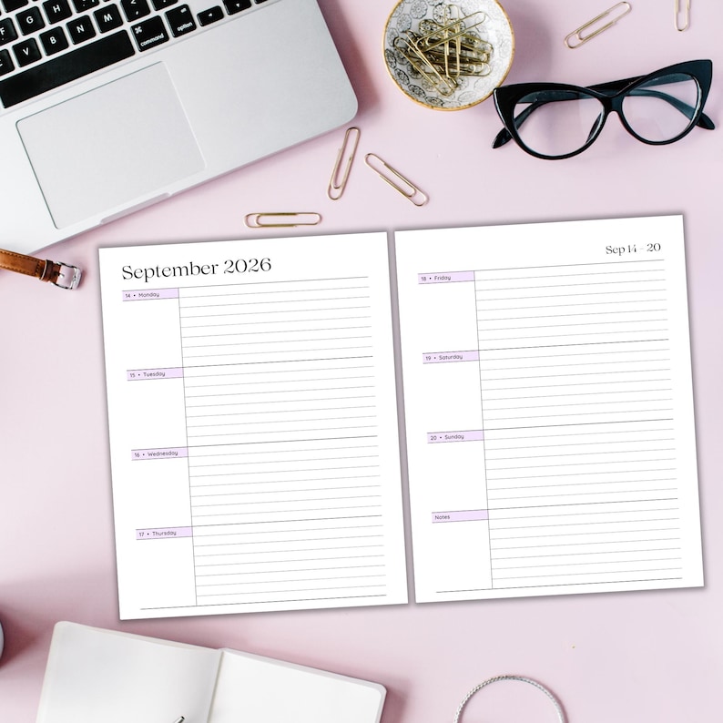 May include: A planner open to a week in September 2026, with lined pages and a light purple accent. A laptop, glasses, paperclips, and a small dish are on a pink surface.