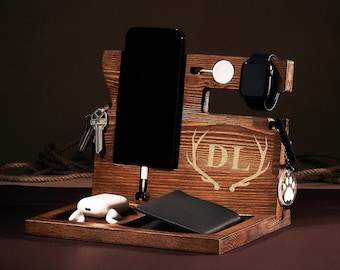 May include: Wooden phone stand with a phone, watch, keys, and a wallet. The stand has a deer antler design and the initials "DL" are engraved on the front.