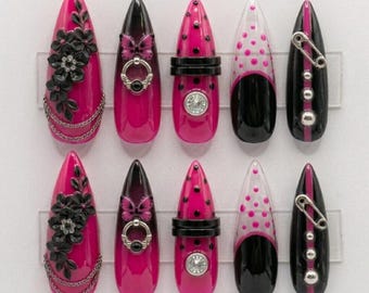 Uñas postizas rosa fucsia estilo gótico, uñas negras con estampado floral 3D, set de uñas punk rock, uñas con dije de mariposa, uñas postizas glamurosas estilo Y2K