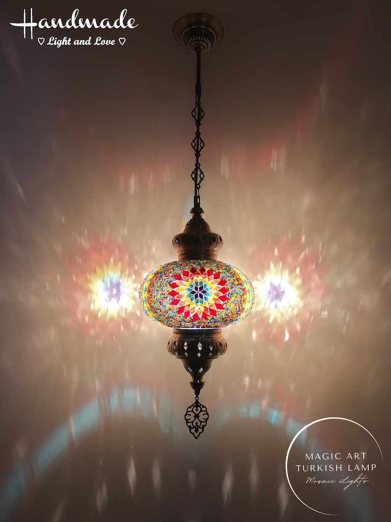 May include: A colorful mosaic Turkish lamp with a starburst design hangs from a chain. The lamp is lit and casts a warm glow on the surrounding area. The text "Magic Art Turkish Lamp Mosaic Lights" is visible in the lower right corner of the image.